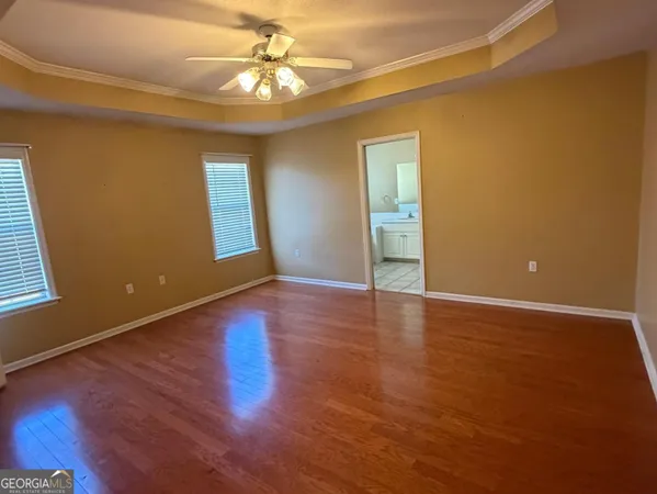 a view of an empty room with window and wooden floor