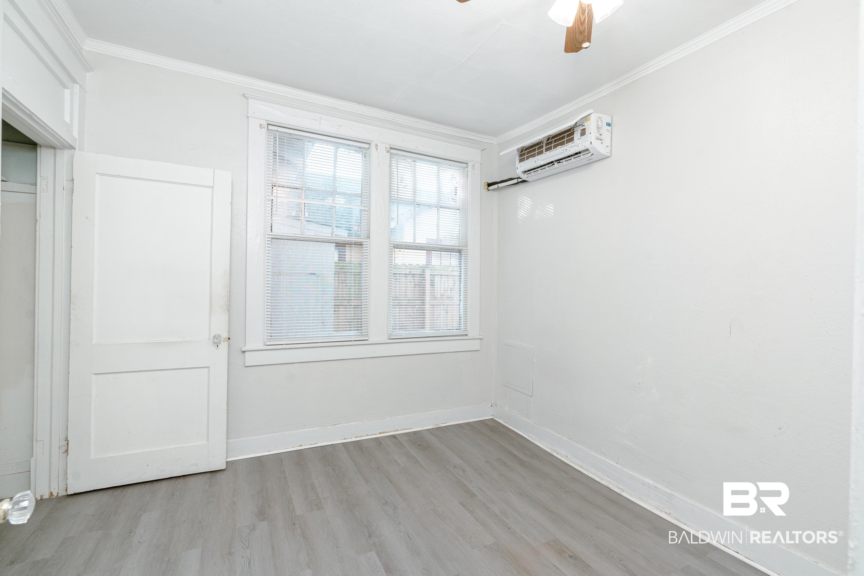 5 North Fulton Street Mobile, AL 36607 - Photo 14 of 55 Unfurnished room with ceiling fan, a wall mounted AC, ornamental molding, and light hardwood / wood-style flooring