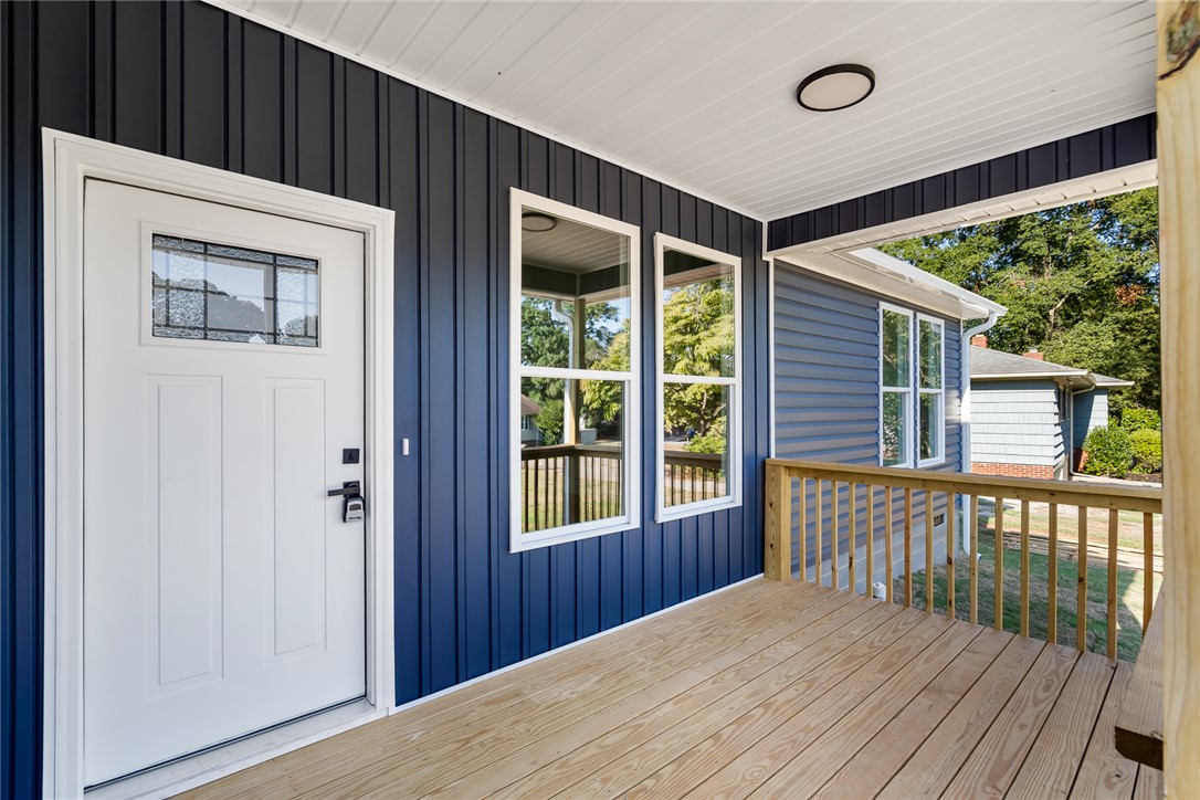 1507 Tindall Avenue Anderson, SC 29621 - Photo 4 of 38 A welcoming front porch features warm wood decking contrasted against modern dark vertical siding.