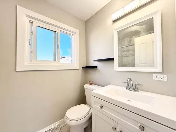 a bathroom with a toilet a sink a vanity and mirror