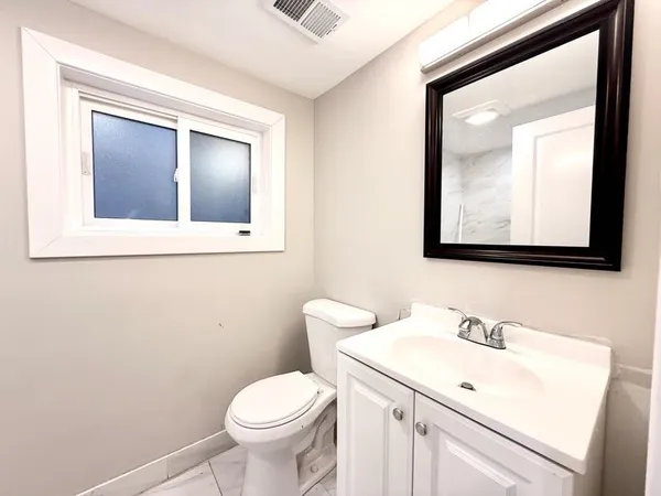 a bathroom with a toilet sink and mirror