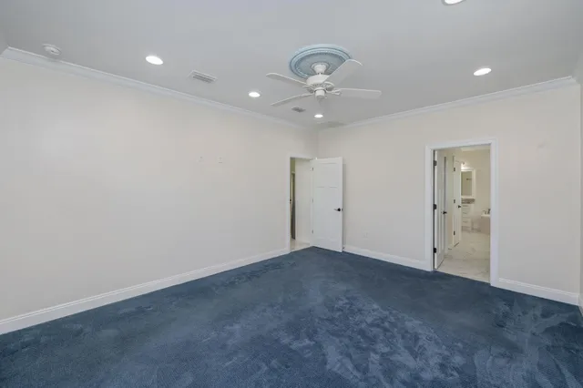 an empty room with a ceiling fan and bathroom view