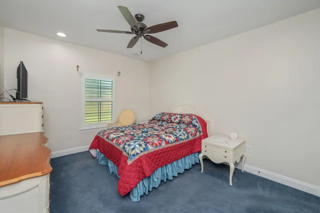 a bedroom with a bed and flat tv screen on the dresser