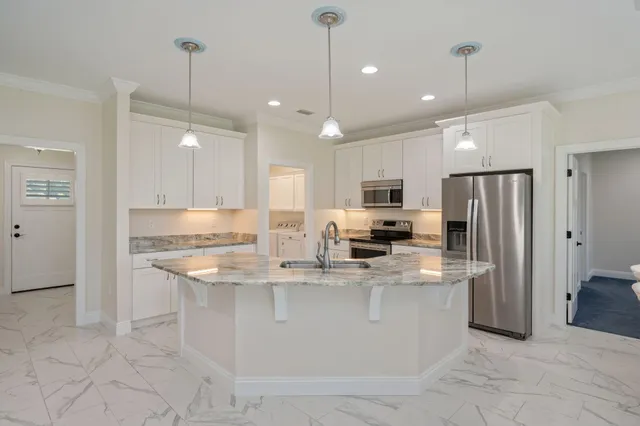 a kitchen with stainless steel appliances granite countertop a stove top oven a refrigerator a sink and a oven