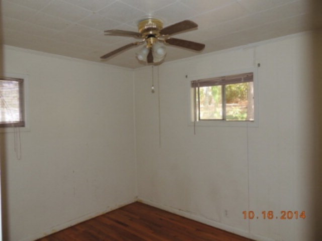 2646 Powersville Road Byron, GA 31008 - Photo 5 of 8 an empty room with wooden floor fan and windows