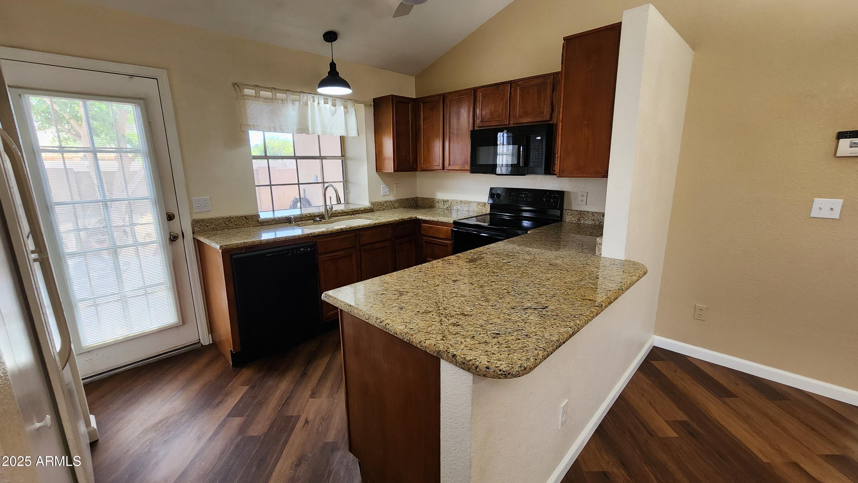 7977 West Wacker Road, Unit 226 Peoria, AZ 85381 - Photo 13 of 19 a kitchen with kitchen island a sink dishwasher a stove and a refrigerator with wooden floor
