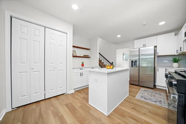 a kitchen with a refrigerator and white cabinets