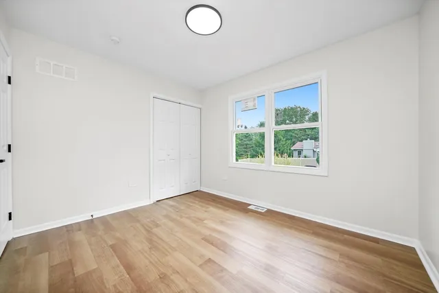 a view of empty room with wooden floor