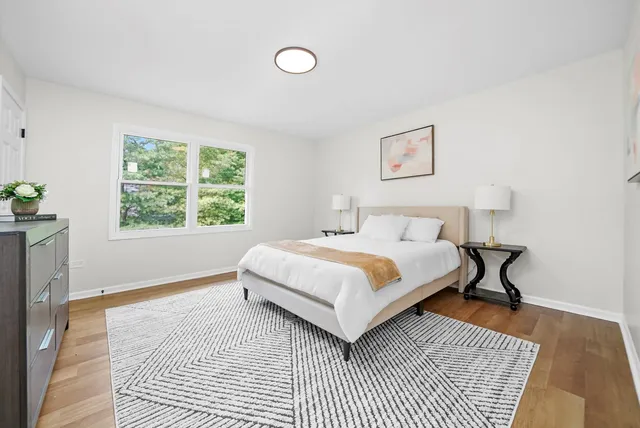 a bedroom with a bed and a wooden floor