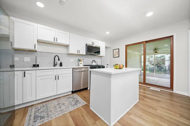 a kitchen with cabinets and wooden floor