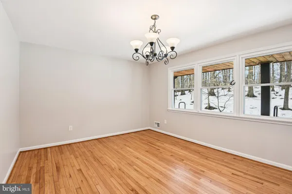 a view of a bedroom with wooden floor and chandelier