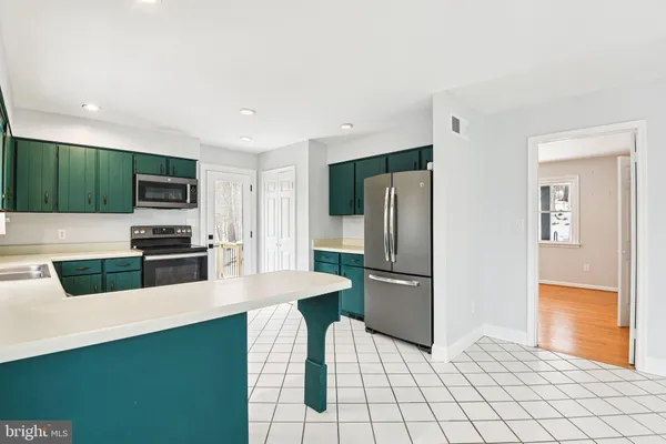 a kitchen with stainless steel appliances a refrigerator sink and microwave