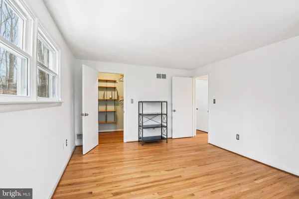 a view of a room with wooden floor and white walls
