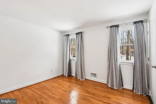 an empty room with wooden floor and a window