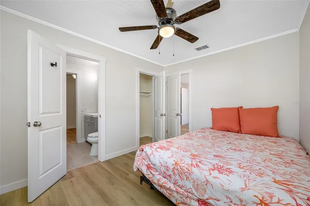 a bedroom with a large bed and a chandelier