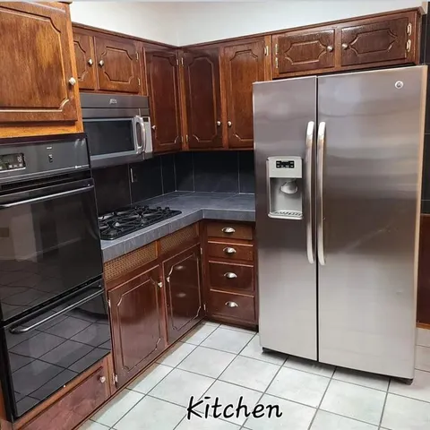 a kitchen with granite countertop a refrigerator and a stove