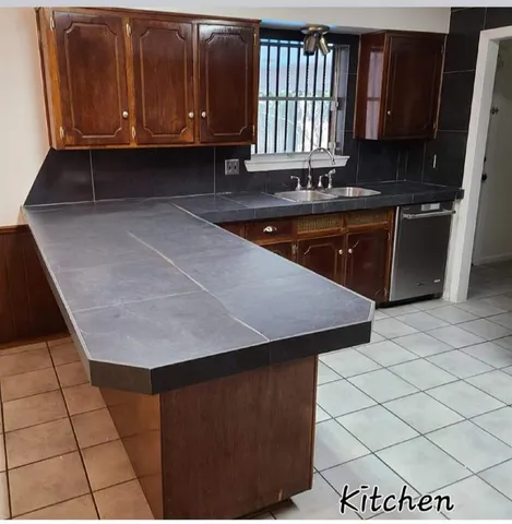 a kitchen with a sink a window and cabinets