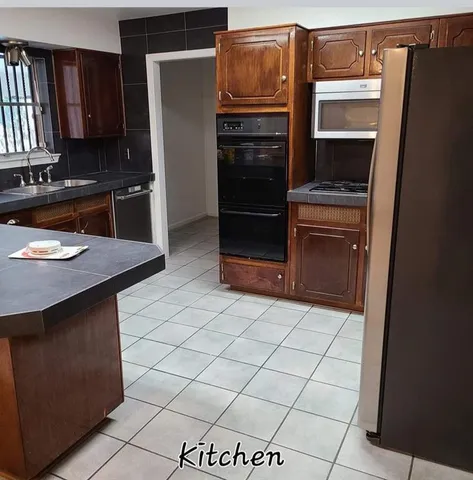 a kitchen with stainless steel appliances a refrigerator and a stove top oven