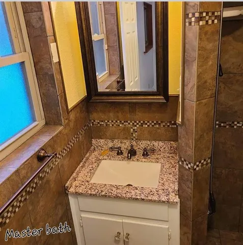 a bathroom with a granite countertop sink and a mirror