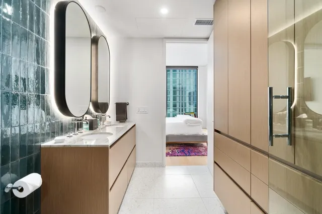 a en suite bathroom with a granite countertop sink and mirror with bathtub