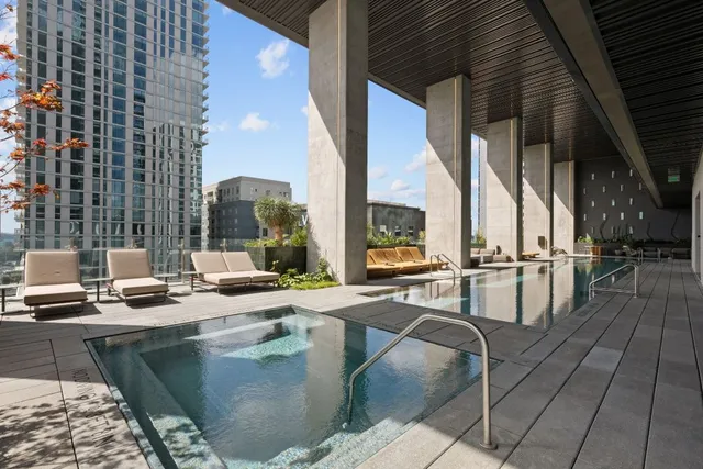 a view of swimming pool with outdoor seating and city view