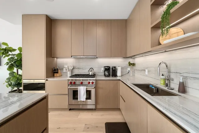 a kitchen with stainless steel appliances granite countertop a sink a stove and a refrigerator