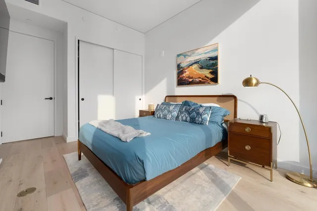 a bedroom with a bed and a painting on the wall