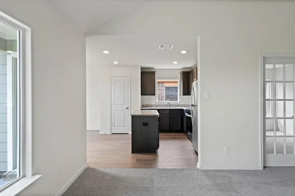 a view of a kitchen with a sink and dishwasher a refrigerator with wooden floor
