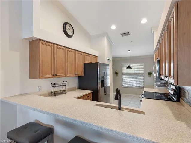 a kitchen with stainless steel appliances granite countertop a sink refrigerator and microwave