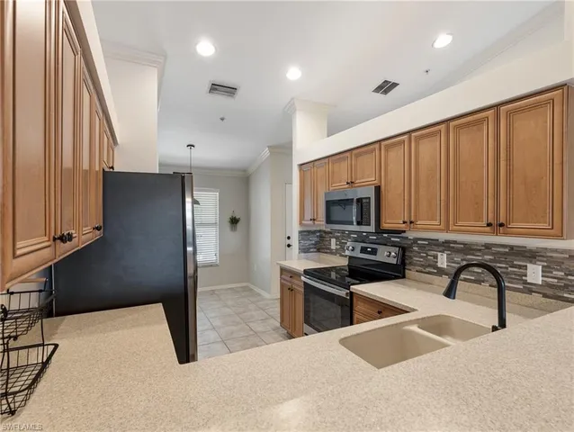 a kitchen with stainless steel appliances granite countertop a refrigerator a stove a sink and a dining table with wooden floor