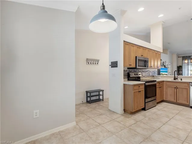a kitchen with a refrigerator and a stove top oven