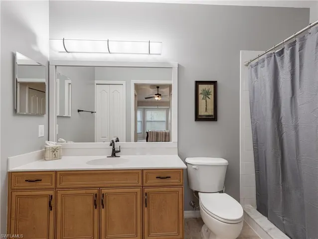 a bathroom with a granite countertop sink mirror vanity and toilet