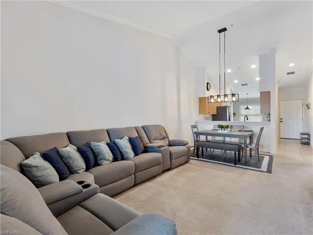 a living room with furniture and kitchen view