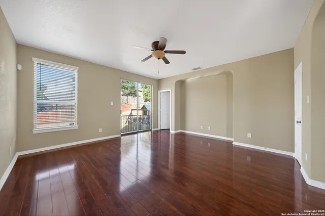 a view of a livingroom with wooden floor and a ceiling fan