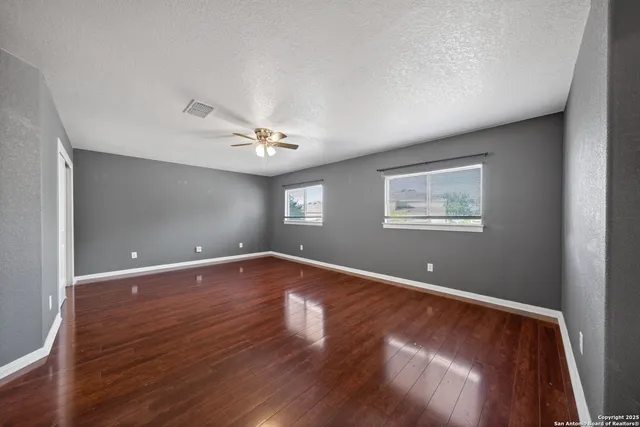 a view of an empty room with wooden floor