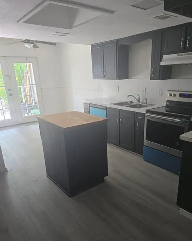 a kitchen with stainless steel appliances granite countertop a stove a sink and a refrigerator