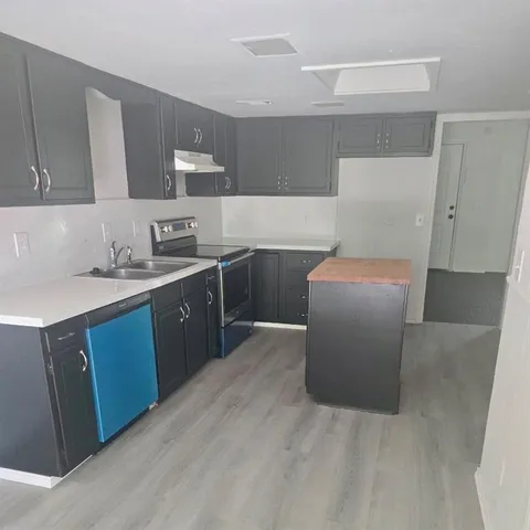 a kitchen with stainless steel appliances a sink stove and cabinets