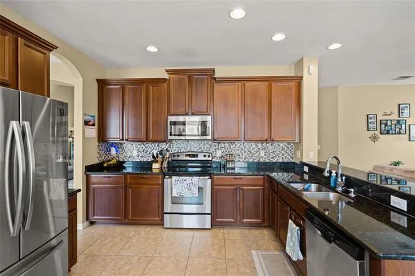 a kitchen with stainless steel appliances kitchen island granite countertop a refrigerator and stove