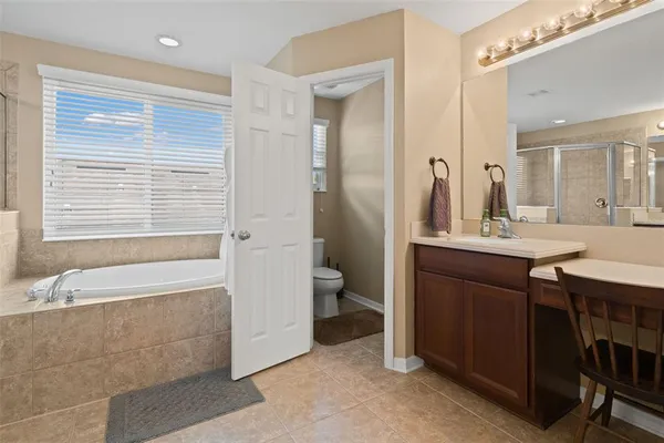 a bathroom with a granite countertop sink a toilet a mirror and shower