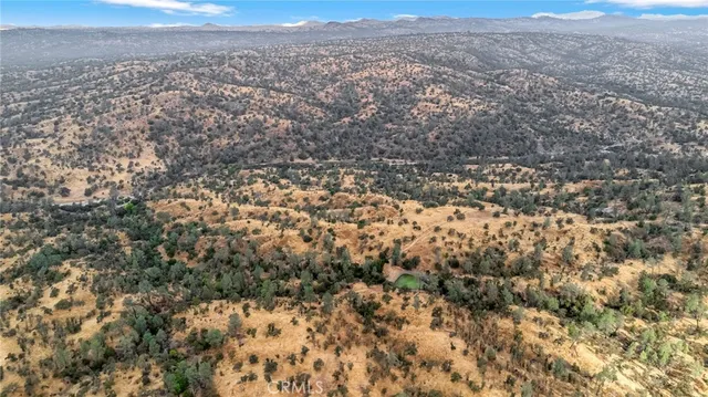 an aerial view of house with yard and mountain view in back
