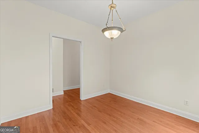 a view of a room with wooden floor and white walls