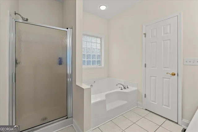 a bathroom with a bathtub a shower a sink and a window