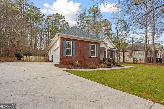 a front view of a house with a garden and tree