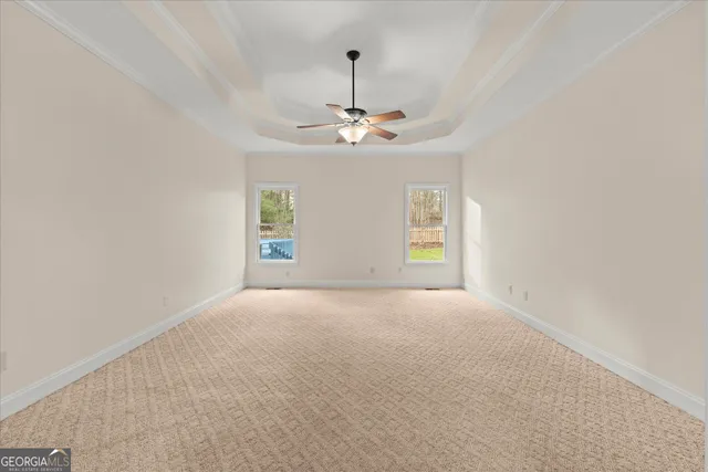 en empty room with windows and ceiling fan