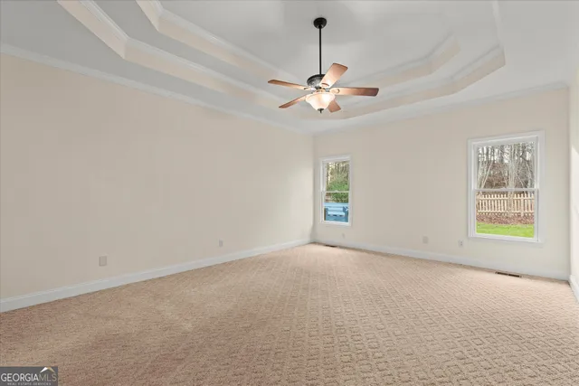 an empty room with windows and fan