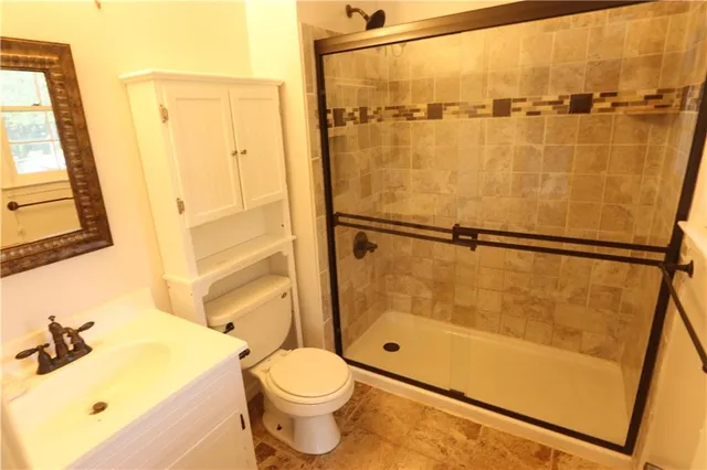 a bathroom with a shower a sink and a toilet