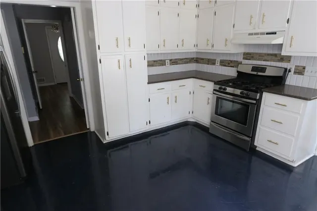 a kitchen with granite countertop white cabinets and white appliances
