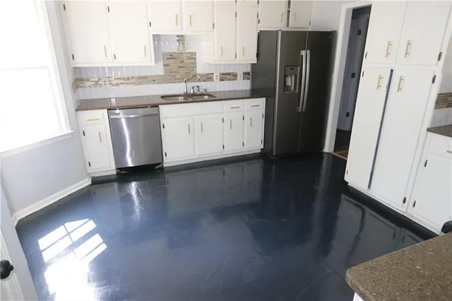 a kitchen with stainless steel appliances granite countertop a refrigerator and a sink