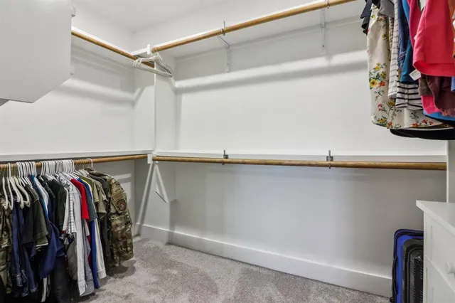 a view of walk in closet with clothes