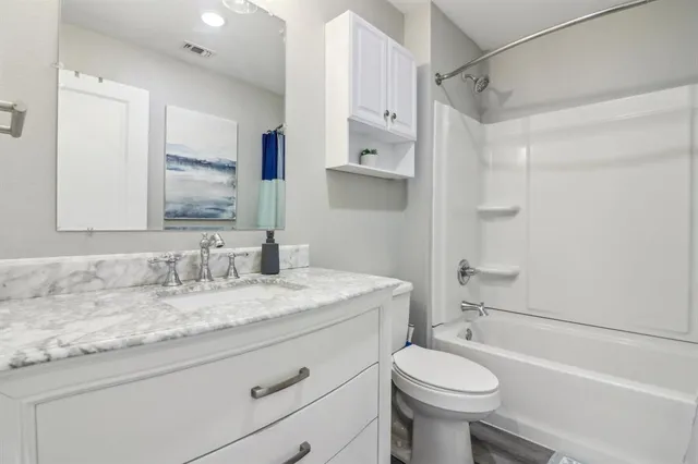 a bathroom with a sink toilet vanity and shower